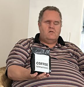 Image of the owner holding up a bag of coffee beans
